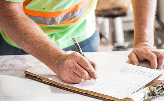 Contractor writing on clipboard