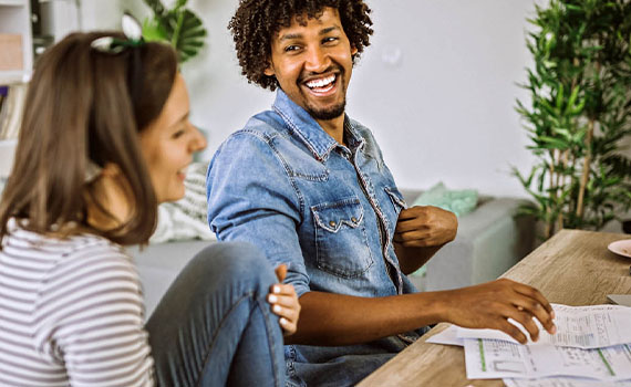 Happy young couple reading documents