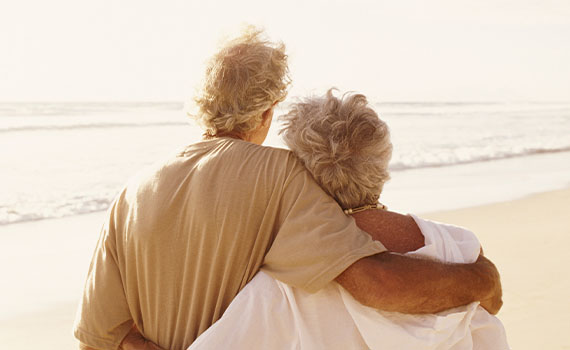 Mature couple walk along the beach
